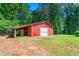 Red outbuilding with lean-to offers covered space for storage, nestled in a grassy yard at 7849 Circle L Trl, Rougemont, NC 27572