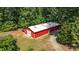 Spacious red barn with a white roof, surrounded by lush trees, offers ample storage at 7849 Circle L Trl, Rougemont, NC 27572