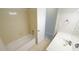 Bathroom featuring a bathtub with tan tile, a vanity, and views into the hallway at 8201 Blue Heron Way, Raleigh, NC 27615