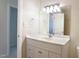 Well-lit bathroom features a vanity, mirror, with a view into the hallway with neutral wall paint at 8201 Blue Heron Way, Raleigh, NC 27615