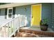 Charming front porch with brick steps, white railing, and a bright yellow door at 8201 Blue Heron Way, Raleigh, NC 27615