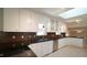 Kitchen features white cabinets, dark countertops, stainless steel appliances, and a skylight at 8201 Blue Heron Way, Raleigh, NC 27615