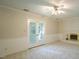 Cozy living room with a fireplace, carpeted floors, and bright doors leading to outdoor area at 8201 Blue Heron Way, Raleigh, NC 27615