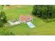 Expansive aerial view of a brick home with an inground pool and large lawn at 8415 Meadow View Ln, Bahama, NC 27503