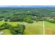 Aerial view of property with lush green trees and large lawn at 8415 Meadow View Ln, Bahama, NC 27503