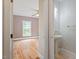 Hallway view of a half-bathroom with floral wallpaper, and doorway to bedroom beyond at 8415 Meadow View Ln, Bahama, NC 27503