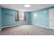 Bedroom with soft blue walls, carpeted floors, and a large window at 8415 Meadow View Ln, Bahama, NC 27503