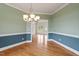 Dining room showcasing wainscoting, an elegant chandelier, and a grand doorway to other rooms at 8415 Meadow View Ln, Bahama, NC 27503