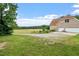 Spacious backyard with lawn and mature trees and driveway at 8415 Meadow View Ln, Bahama, NC 27503