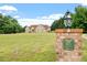 Brick entrance to a home with a lush lawn and surrounded by large trees at 8415 Meadow View Ln, Bahama, NC 27503