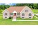 Charming brick home with red shutters, a red front door, and a manicured lawn at 8415 Meadow View Ln, Bahama, NC 27503