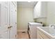 Bright laundry room with tiled floor, washer, dryer, and overhead storage cabinets at 8415 Meadow View Ln, Bahama, NC 27503