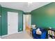 Cozy bedroom featuring a ceiling fan, white door, and a comfy blue chair at 8620 Neuse Club Ln # 107, Raleigh, NC 27616