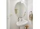 Bathroom featuring pedestal sink, round mirror, and stylish decor at 903 Grace Point Rd, Morrisville, NC 27560
