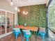 Dining area features a wooden table, bright blue chairs, leafy wall, industrial lighting, and a view at 903 Grace Point Rd, Morrisville, NC 27560