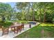 Beautiful backyard setting with a patio dining area, outdoor seating, swing set and mature trees at 1100 Brooks Ave, Raleigh, NC 27607
