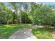 Expansive backyard featuring a lush lawn, mature trees, a playground, and a cozy patio area at 1100 Brooks Ave, Raleigh, NC 27607