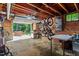 Open basement with exposed brick, offering a versatile space for storage or recreation with access to an outdoor patio at 1100 Brooks Ave, Raleigh, NC 27607