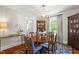 Open dining room with wood table, area rug, decorative cabinet and modern light fixture at 1100 Brooks Ave, Raleigh, NC 27607
