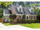 Charming brick home featuring dormer windows, complemented by well-maintained landscaping and a welcoming front yard at 1100 Brooks Ave, Raleigh, NC 27607