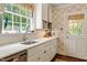 Bright kitchen with white cabinets, marble countertops, stainless steel appliances, and patterned wallpaper at 1100 Brooks Ave, Raleigh, NC 27607