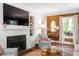 Cozy living room with fireplace, built-in shelving, and a large window for natural light at 1100 Brooks Ave, Raleigh, NC 27607