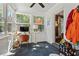 Bright sunroom features a slate floor, large windows, and is staged as an office with hanging art at 1100 Brooks Ave, Raleigh, NC 27607