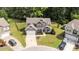 Aerial view of the home with a manicured lawn, landscaping, and paved driveways at 112 Pearsall Farm Ln, Clayton, NC 27527