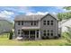 Rear exterior view showing the outdoor kitchen, screened in porch, and manicured backyard at 112 Pearsall Farm Ln, Clayton, NC 27527
