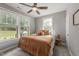 Bright bedroom with natural light, featuring neutral walls, ceiling fan and outdoor view at 112 Pearsall Farm Ln, Clayton, NC 27527