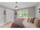 Cozy bedroom with hardwood floors and natural light from a large picture window at 112 Pearsall Farm Ln, Clayton, NC 27527