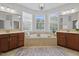 Luxurious bathroom features a soaking tub, double vanity, and natural light from windows at 113 Market Cross Ct, Holly Springs, NC 27540