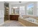 Beautiful bathroom with soaking tub, a walk-in shower, and lots of natural light at 113 Market Cross Ct, Holly Springs, NC 27540