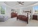 Spacious bedroom with a ceiling fan, a cozy sitting area, and natural light at 113 Market Cross Ct, Holly Springs, NC 27540