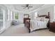 Large bedroom with tray ceiling, a sitting area, and natural light from multiple windows at 113 Market Cross Ct, Holly Springs, NC 27540
