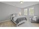 Cozy bedroom features a comfortable bed, reading chair and sunlit windows for plenty of natural light at 113 Market Cross Ct, Holly Springs, NC 27540