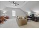 Bright bonus room features neutral carpet, a ceiling fan, seating area, and a view of the window at 113 Market Cross Ct, Holly Springs, NC 27540
