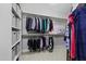 Walk-in closet offers ample storage with organized shelving, rods, and neutral carpeting at 113 Market Cross Ct, Holly Springs, NC 27540