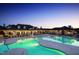 Aerial view of a neighborhood clubhouse and pool at dusk. The clubhouse is well-lit at 113 Market Cross Ct, Holly Springs, NC 27540