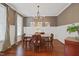 Elegant dining room featuring hardwood floors, wainscoting, and a decorative chandelier above the dining table at 113 Market Cross Ct, Holly Springs, NC 27540