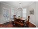 Dining room with a wooden table, bench seating, modern lighting and natural light at 113 Market Cross Ct, Holly Springs, NC 27540