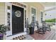 Charming front porch with a welcoming door, rocking chairs, and decorative plants at 113 Market Cross Ct, Holly Springs, NC 27540