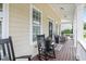 Cozy front porch features rocking chairs and a decorative welcome mat, creating a warm entrance at 113 Market Cross Ct, Holly Springs, NC 27540