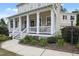 Inviting front porch with white columns and railings, adorned with seasonal flowers and greenery at 113 Market Cross Ct, Holly Springs, NC 27540