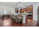 Bright kitchen features an island with seating, stainless appliances, and hardwood flooring at 113 Market Cross Ct, Holly Springs, NC 27540