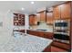 Well-equipped kitchen with granite counters, stainless appliances and custom wood cabinetry at 113 Market Cross Ct, Holly Springs, NC 27540