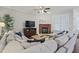 Cozy living room with fireplace, ceiling fan, and plush sectional sofa at 113 Market Cross Ct, Holly Springs, NC 27540