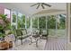 Enjoy this screened porch with comfortable seating, a ceiling fan, and peaceful views at 113 Market Cross Ct, Holly Springs, NC 27540
