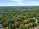 Aerial view of a neighborhood nestled in a lush forest setting at 116 Berry Hill Dr, Raleigh, NC 27615