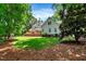 Spacious backyard featuring a large deck, lush green lawn, and mature trees at 116 Berry Hill Dr, Raleigh, NC 27615